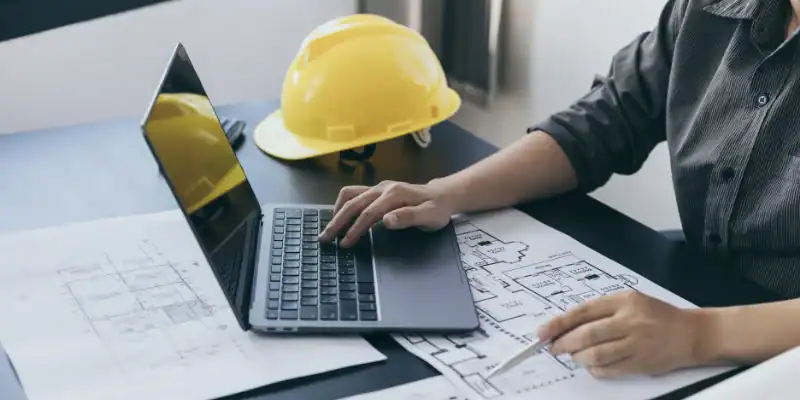 pre-construction-and-design-support-for-commercial-roofing-systems A construction project manager reviewing pre-construction and design support for commercial roofing systems